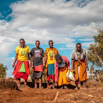 A group of women from the Maasai Lemong’o Women’s Vision spread grass seeds over earth bunds