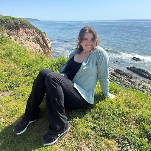 Maggie D’Amaro on a cliffside above the ocean