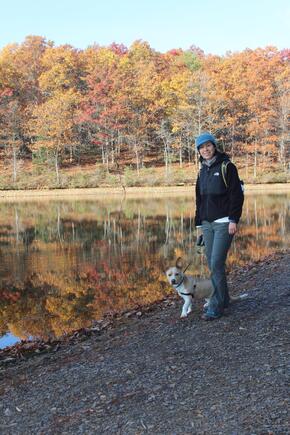 Mary Jo Snavely stands by a lake with her dog