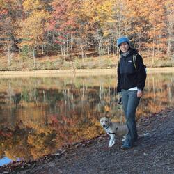 Mary Jo Snavely stands by a lake with her dog