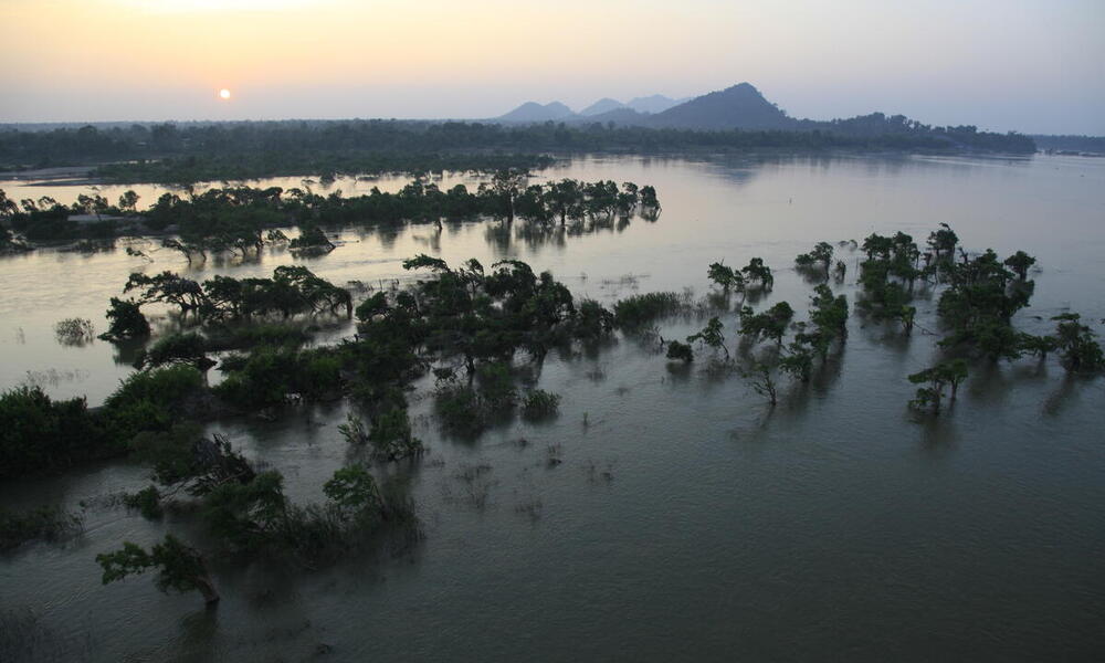 Aerial of sunset, with islets in front and misty mountains at the back, Cambodia