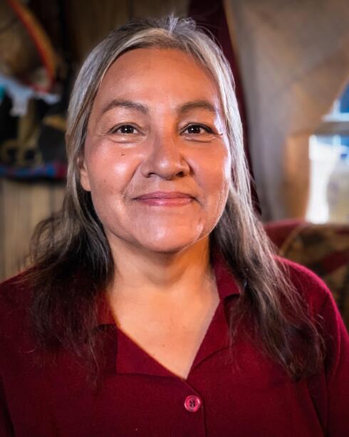 A portrait of Monica Rattling Hawk smiling into the camera in 2020
