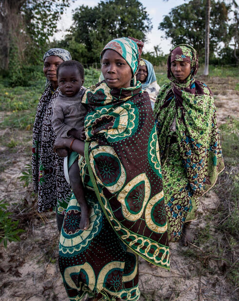 Women in indigenous clothing pose for camera