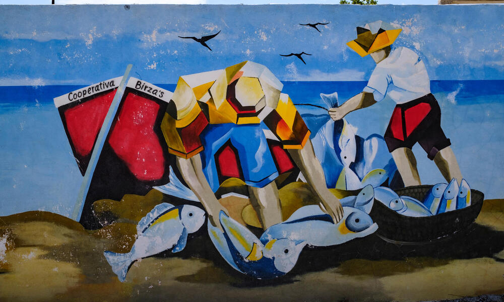 Colorful painted mural showing people seaside with daily catch