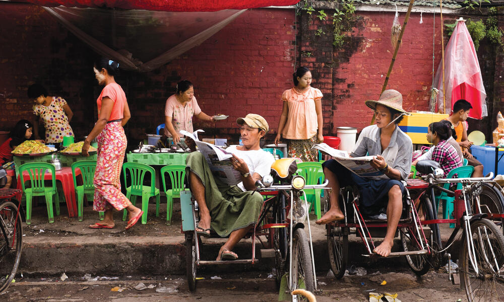 Locals eat, drink, talk—and take in the news—at a streetside teashop on Pansodan Jetty in downtown Yangon.