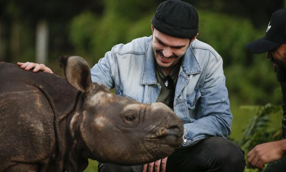 Nicholas Hoult with a baby rhino