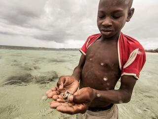 A Nuarro boy shows off his method for catching fish