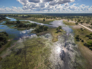 Aerial view of flood water arriving to the Okavango Delta, Botswana under blue cloudy skies
