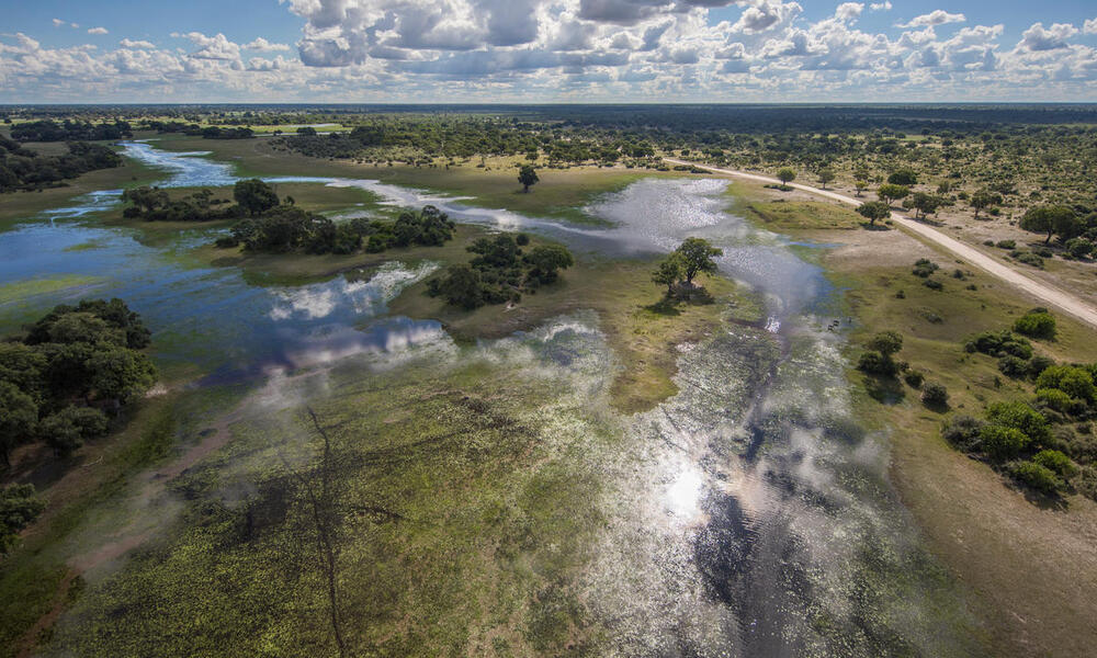 Aerial view of flood water arriving to the Okavango Delta, Botswana under blue cloudy skies