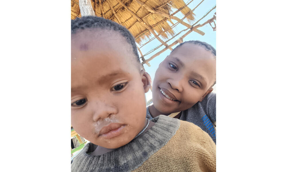 A woman and child look down at camera