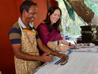 Two people working on textiles at a table