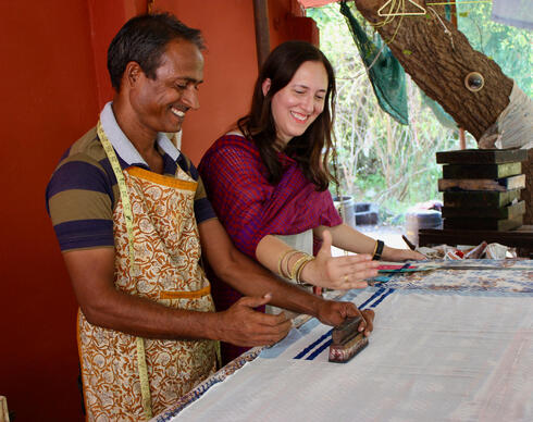 Two people working on textiles at a table
