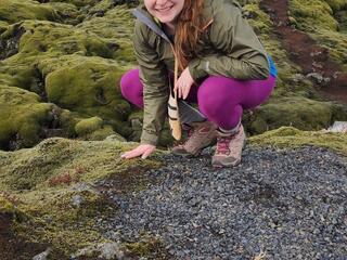 Rachel Golden Kroner crouches before a mossy landscape