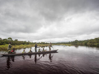 rangers paddle down a river in Salonga National Park