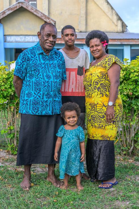 In Nacula Village, Yasawa Islands, Fiji, Ratu Manasa Bogileka Naikasowalu stands with his wife, son, and granddaugther