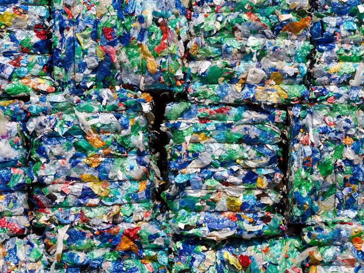 A closeup of colorful recycled plastics crushed into flat stacks