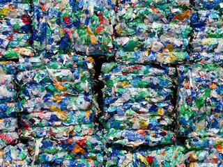 A closeup of colorful recycled plastics crushed into flat stacks