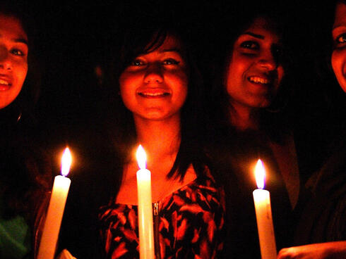 Revellers with candles celebrate Earth Hour at Dunedin's Octagon community event, South Island, New Zealand.