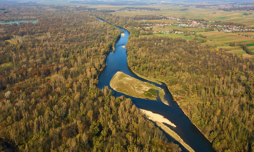 Aerial view of the River Mura with a town in the distance