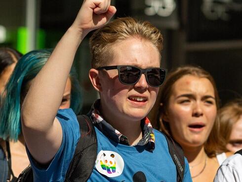 Blonde hair man with sunglasses and fist up at a march