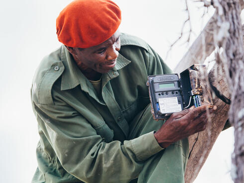 A wildlife ranger fixing a camera trap in Selous