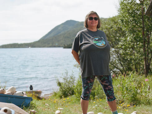 Cloud standing on shore with boats in background