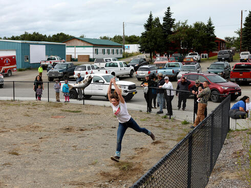 Woman tossing large fish with onlookers