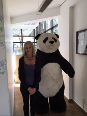 Sheila Bonini stands next to a giant panda costume.