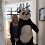 Sheila Bonini stands next to a giant panda costume.
