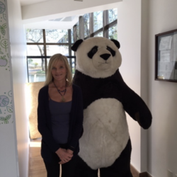 Sheila Bonini stands next to a giant panda costume.