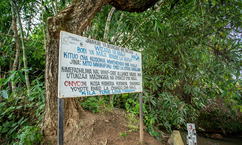 A sign along a riverbank about water conservation