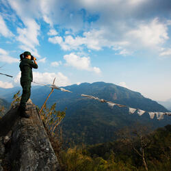 Singye Wangmo, a Bhutan forestry officer looking through her binoculars.
