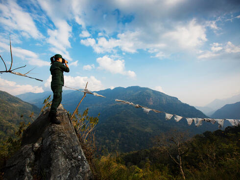 Singye Wangmo, a Bhutan forestry officer looking through her binoculars.