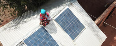 Woman on roof adjusting solar panels