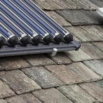 Solar voltaic electricity generating panels and solar hot water panels on a house roof in Ambleside, Cumbria, UK.