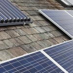 Solar voltaic electricity generating panels and solar hot water panels on a house roof in Ambleside, Cumbria, UK.