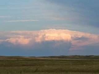 Landscape view of a storm cloud rolling over a grassland landscape in the Northern Great Plains