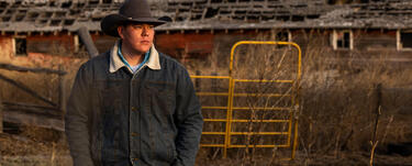 TJ Heinert stands for a portrait in front of a barn at the Wolakota Buffalo Range on the Rosebud Sioux Reservation in South Dakota
