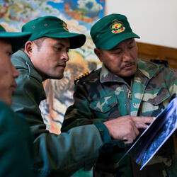 Government rangers at Jigme Singye Wangchuck National Park head office  studying images of tigers captured by camera trapping technique. Jigme Singye Wangchuck National Park, Bhutan.