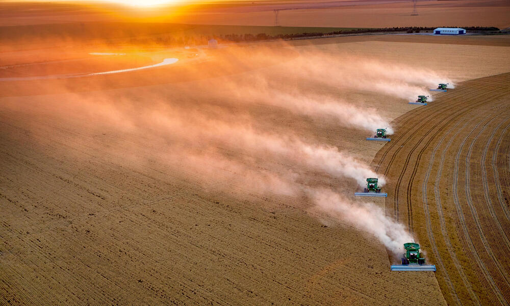 Tractors lined up and driving across field