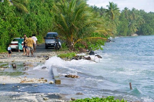 Ocean washing over a road in Tuvalu