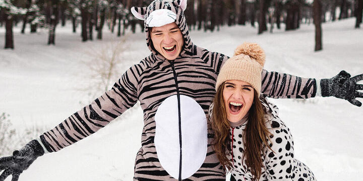 Young adults in animal costumes having fun in the snowy winter forest