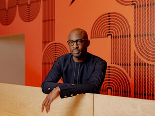 Uzodinma Iweala stands in front of a bright wall