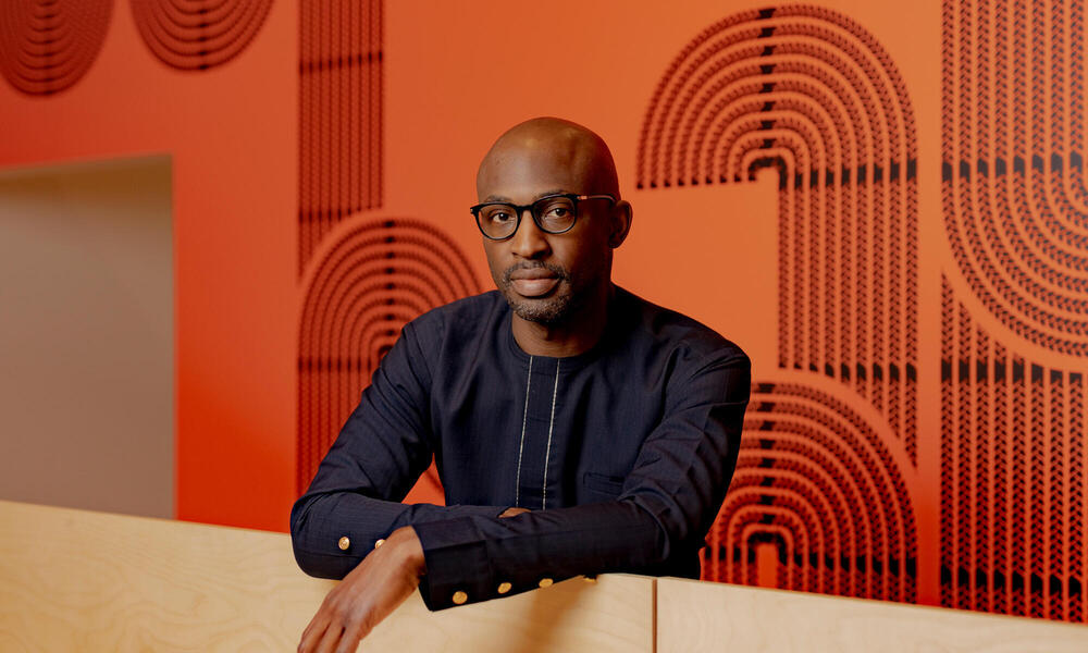 Uzodinma Iweala stands in front of a bright wall