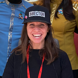 Valerie Weiss surrounded by actors in costume in front of "Starfleet Command" sign