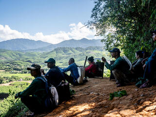 Hikers rest after walking Viet Nam hills in background