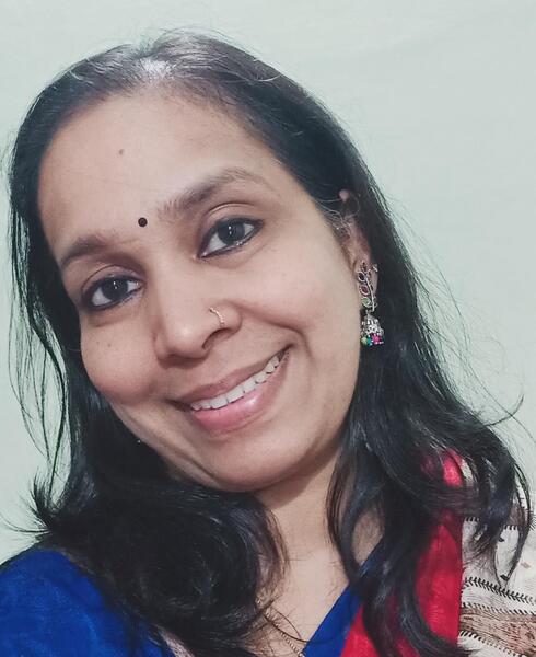 Portrait of Vineetha Aravind smiling at the camera with a white background