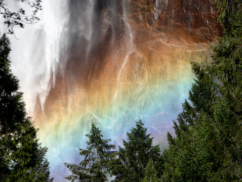 Light through waterfall creates rainbow