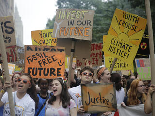 People carry a banners and signs to the start of the People's Climate March in New York City