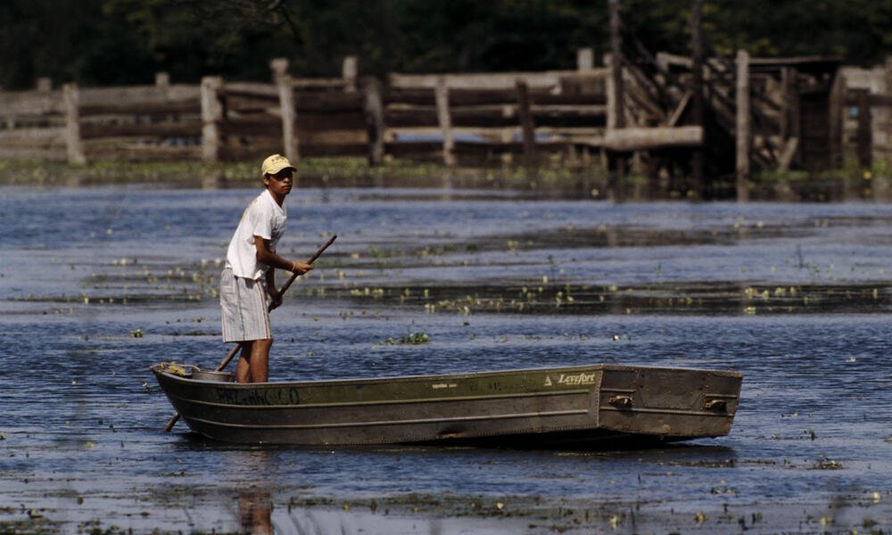 A boy in a flat boat in Pantanal, Brazil.